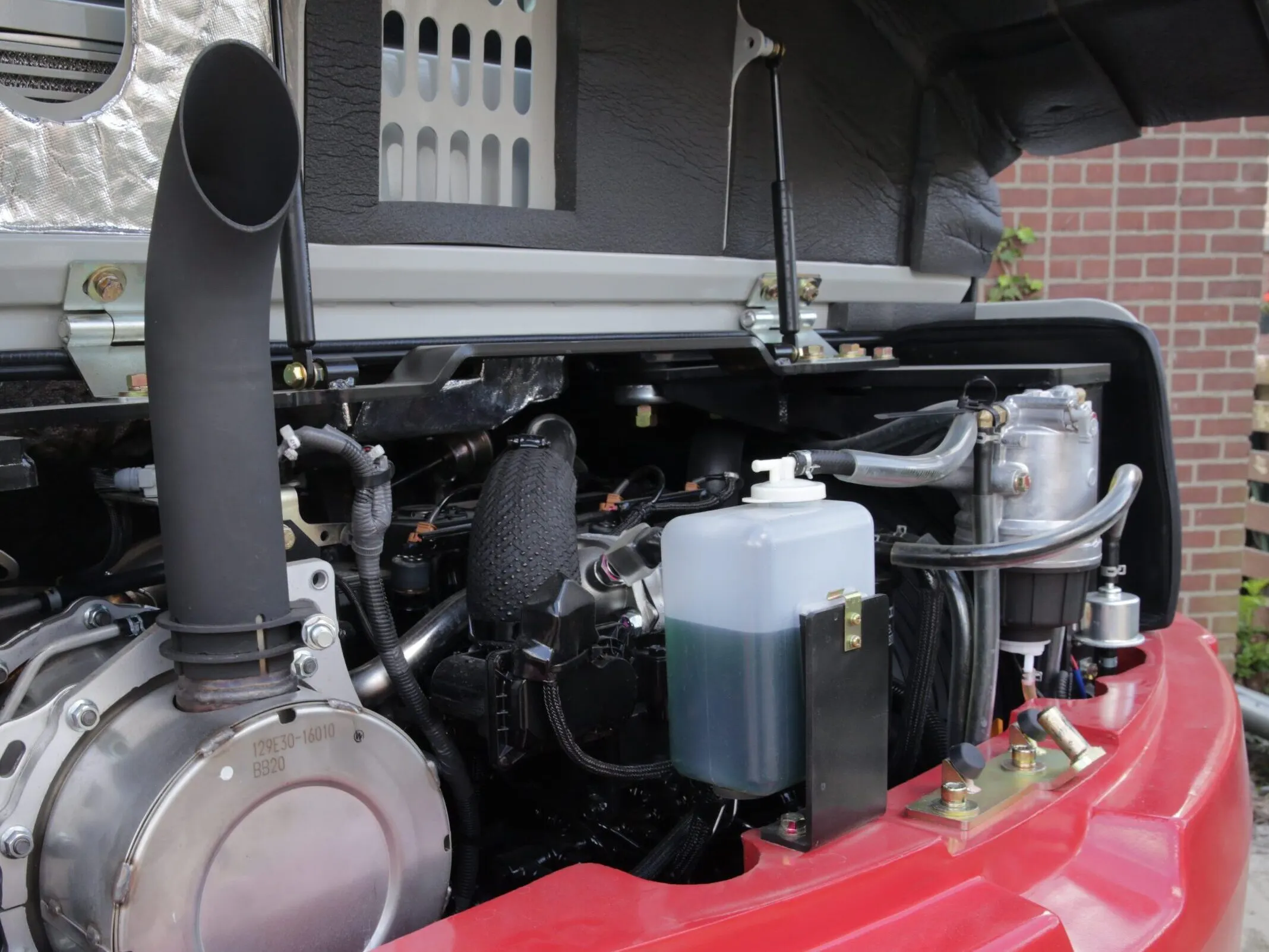 Het motorcompartiment van een Takeuchi met een omhoog gepositioneerde uitlaat