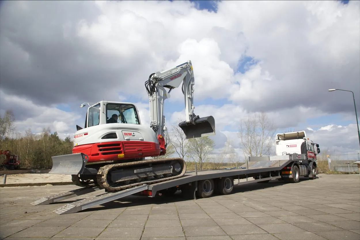 Takeuchi TB290-2 two piece boom rijdt op een dieplader voor transport