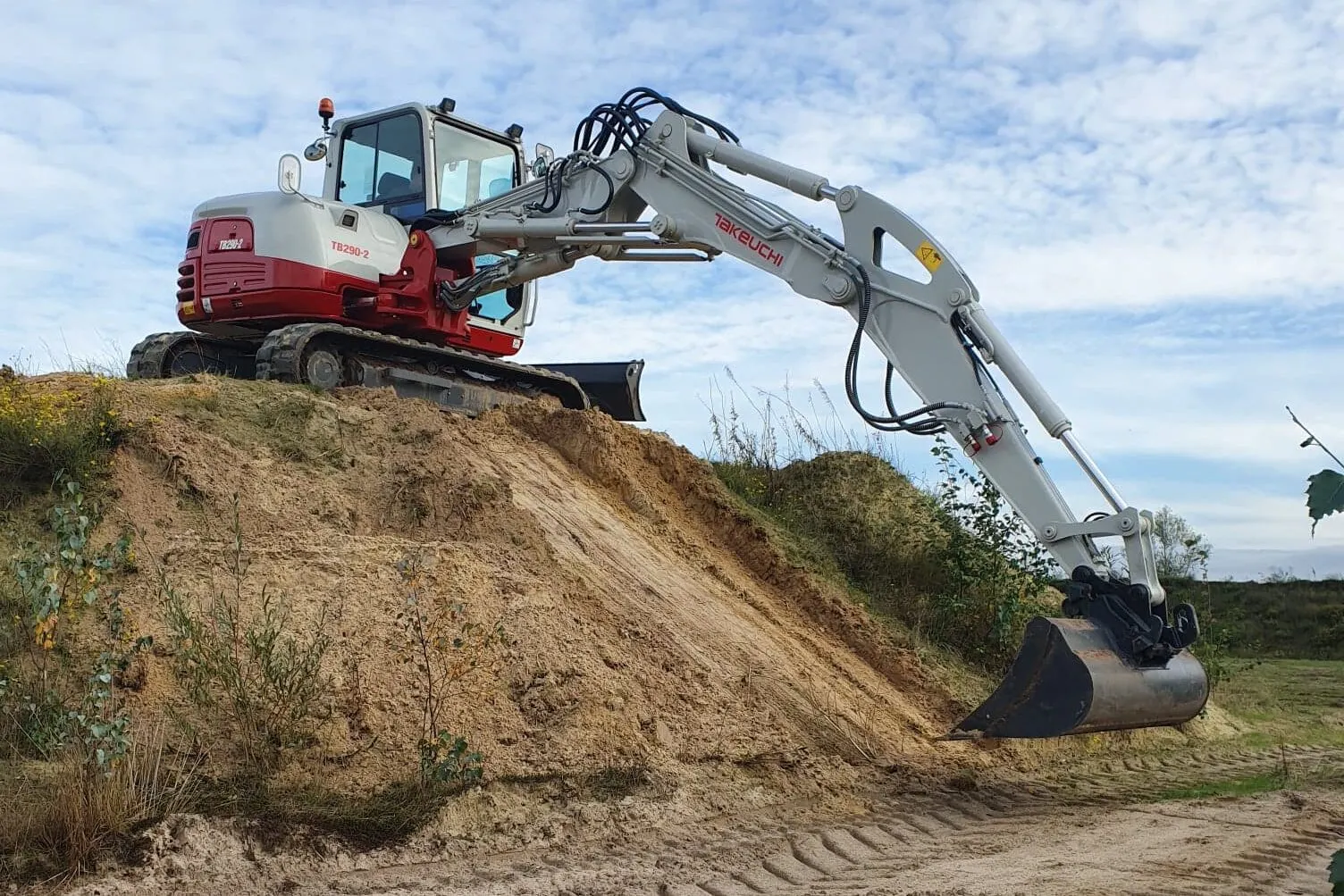 Takeuchi TB290-2 two piece boom op een berg zand